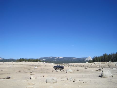 1989 Ford Bronco - A black Ford Bronco is parked in a wide, barren landscape under a clear blue sky.