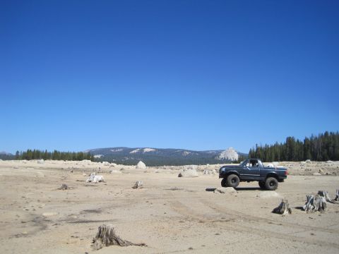 1989 Ford Bronco - A dark blue 1987 Ford Bronco is parked in a barren, rocky landscape under a clear blue sky.