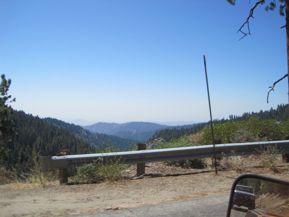 Mountain landscape with guardrail and distant hills under a clear blue sky