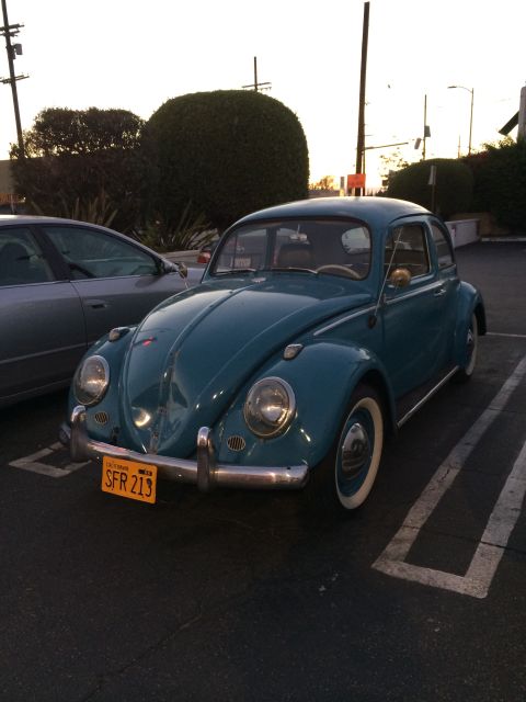 1968 Ford Mustang - This teal Volkswagen Beetle is parked in a lot, showing its distinctive rounded body style and California license plate.