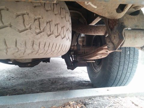 2000 Mercury Grand Marquis - Underside view of a vehicle's rear suspension components and spare tire.