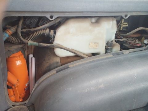2000 Mercury Grand Marquis - Windshield washer fluid reservoir and orange jack visible in the interior of a vehicle.