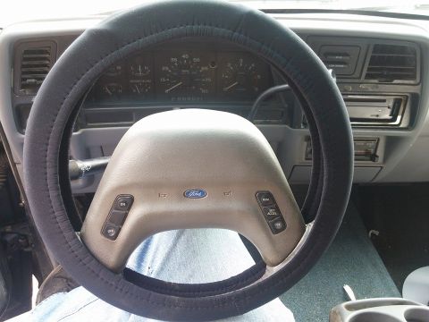 2000 Mercury Grand Marquis - Interior view of a Ford vehicle's steering wheel and dashboard, showing the instrument cluster and center console.