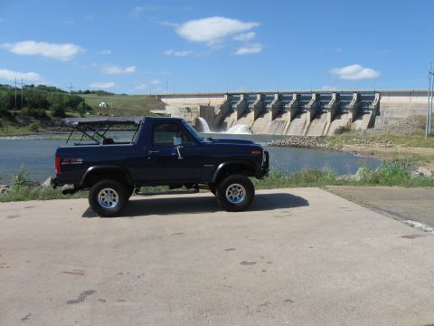 1982 Ford Bronco - 1982 Ford Bronco parked near a dam with water flowing.