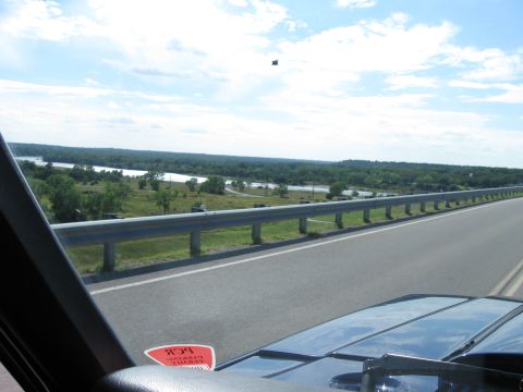 1982 Ford Bronco - Driving on a highway with a scenic view of a river and wooded area.