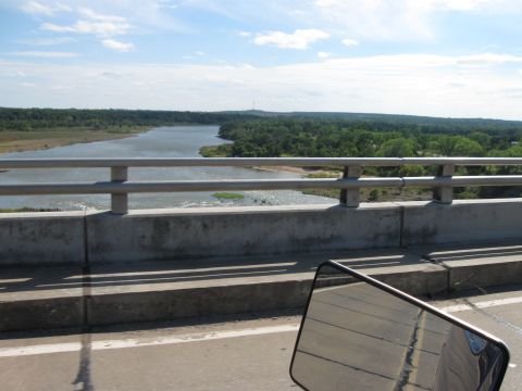 1982 Ford Bronco - River landscape viewed from a bridge, with a side mirror reflecting the road ahead.
