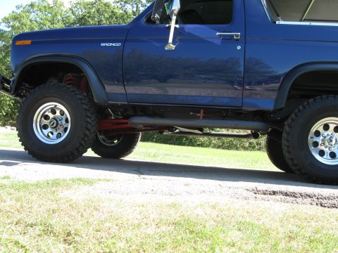 1982 Ford Bronco - This blue Ford Bronco features an elevated suspension system and tires, ready for off-road adventures.