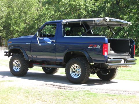 1982 Ford Bronco - This lifted Ford Bronco features a removable soft top and FX4 off-road badging, indicating its capability for terrain.