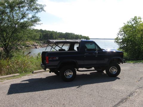 1982 Ford Bronco - This 1982 Ford Bronco is parked on a paved area next to a body of water.