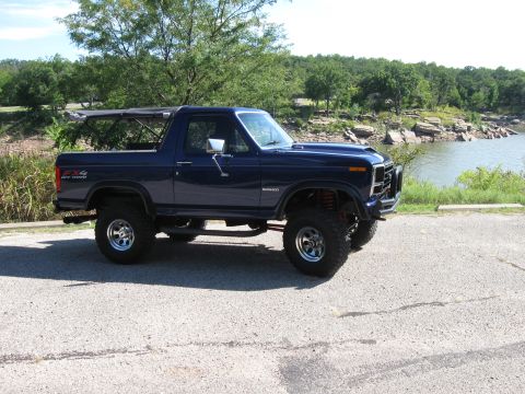 1982 Ford Bronco - This lifted 1982 Ford Bronco sits parked near a lake on a sunny day.