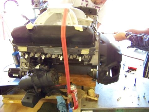 1974 Dodge Challenger - Engine being worked on by two individuals in a garage setting.