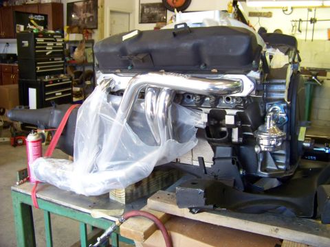 1974 Dodge Challenger - Engine assembly, partially covered, sits on a workbench in a garage setting.