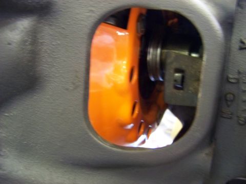 1974 Dodge Challenger - A close-up view shows an orange engine part through an opening in a gray housing.