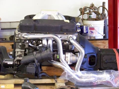 1974 Dodge Challenger - Engine assembly with chrome headers and intake manifold, likely undergoing installation or repair.