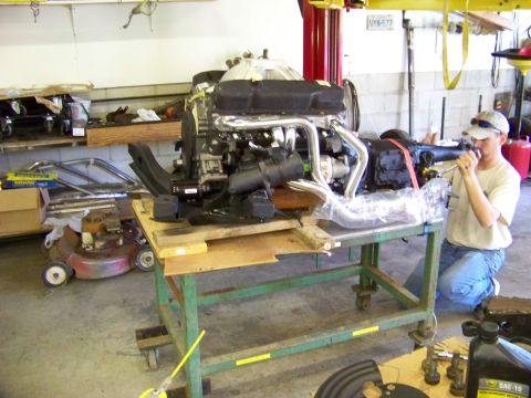 1974 Dodge Challenger - Engine and transmission assembly on a cart in a garage, with a person working in the background.
