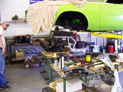 1974 Dodge Challenger - Engine installation in progress on a 1974 Dodge Challenger, with the car body elevated on a lift.