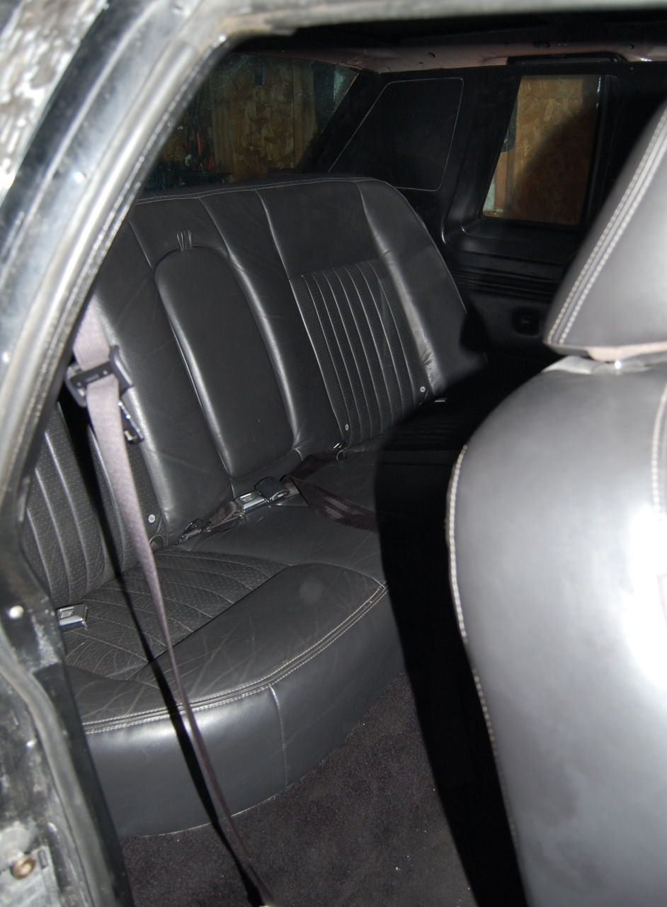 Interior rear seats with black leather upholstery and seatbelts