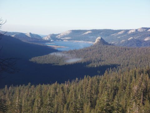 1968 Ford Bronco - Mountain landscape with a lake and dense pine forest under a clear sky.
