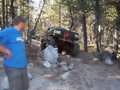 1968 Ford Bronco - A modified black truck navigates a rocky trail with a second vehicle following behind.