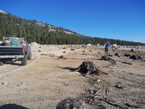 1968 Ford Bronco - Truck loaded with debris in a deforested landscape under a clear blue sky.