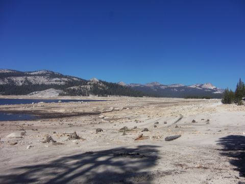 1968 Ford Bronco - A vast, dry lake bed stretches towards distant mountains under a bright blue sky.
