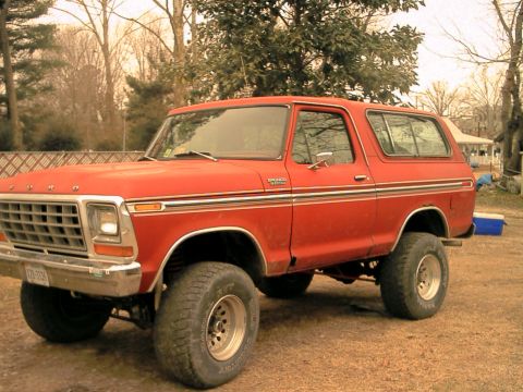 1978 Ford Bronco - This red 1978 Ford Bronco is shown from a three-quarter front view, parked on a dirt lot.