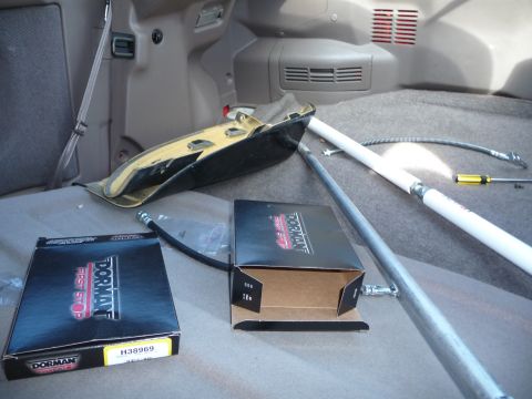 1993 Mazda MX-3 - Parts and tools are laid out in the cargo area of a vehicle.