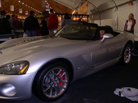 1990 Ford Bronco - A silver convertible sports car, identified by its Viper badging, is displayed indoors with people in the background.