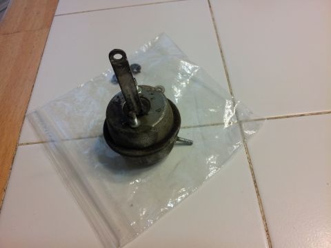 1976 Ford Ranchero - A vacuum actuator part is shown, with numbers stamped on its surface.