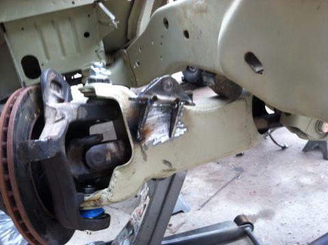 1995 Ford Bronco - Close-up view of a vehicle's front suspension components, including the brake rotor and ball joint, during a repair or modification.