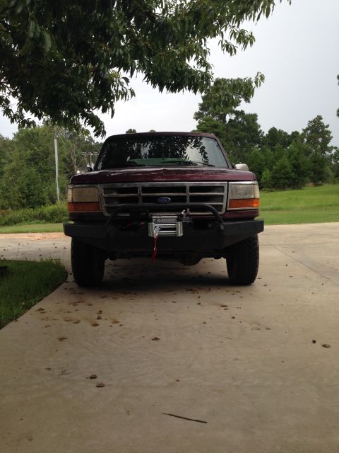 1996 Ford Bronco - This maroon Ford truck features an aftermarket bumper and winch, seen from the front.