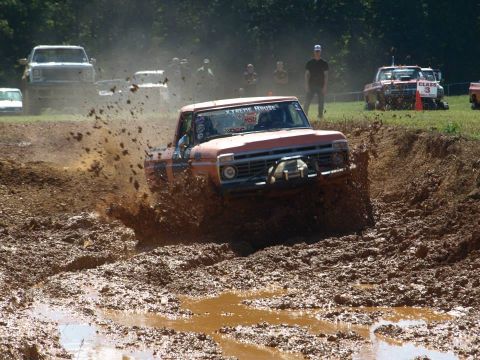 1978 Ford Bronco - Pickup truck navigates a challenging mud obstacle during an off-road event.