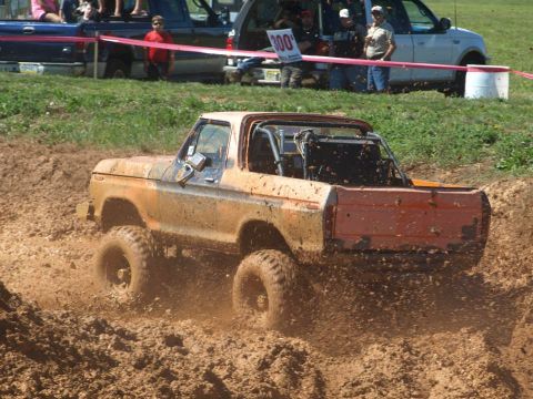1978 Ford Bronco - This 1978 Ford Bronco is navigating a muddy off-road course, kicking up dirt.