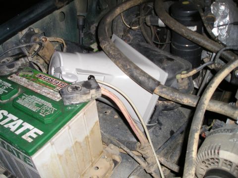 1996 Ford Bronco - Close-up view of a vehicle's engine bay, focusing on the battery and surrounding components.