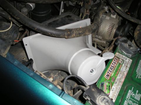 1996 Ford Bronco - Close-up view of an engine bay, showing a white plastic component and an Interstate battery.