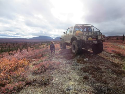1990 Ford F-250 - A modified pickup truck sits on a hill overlooking a vast landscape of autumn-colored vegetation.