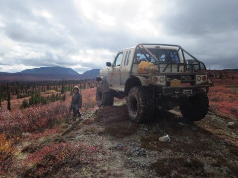 1990 Ford F-250 - A heavily modified pickup truck sits on a remote, hilly terrain under a cloudy sky.