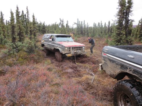1990 Ford F-250 - Two trucks are stuck in the mud, with one attempting to tow the other out.