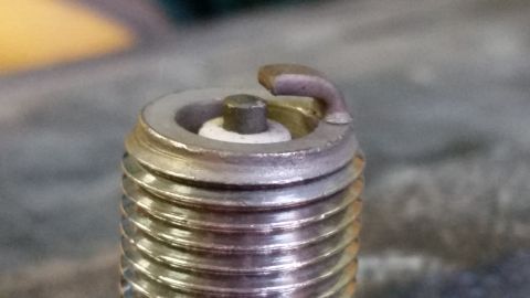 1995 Ford Bronco - This image shows a close-up view of a single spark plug, highlighting its electrode and threaded base.