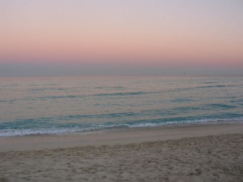 1995 Ford Bronco - A tranquil beach scene at dusk with calm ocean waters and a sandy shore.