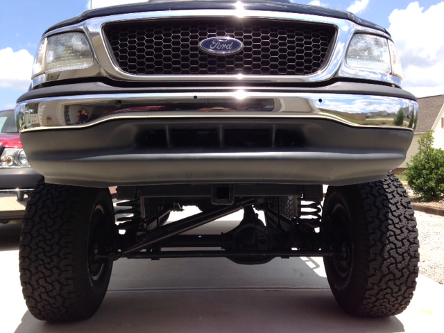 Front view of a lifted 2000 Ford F-150 with a chrome grille and bumper