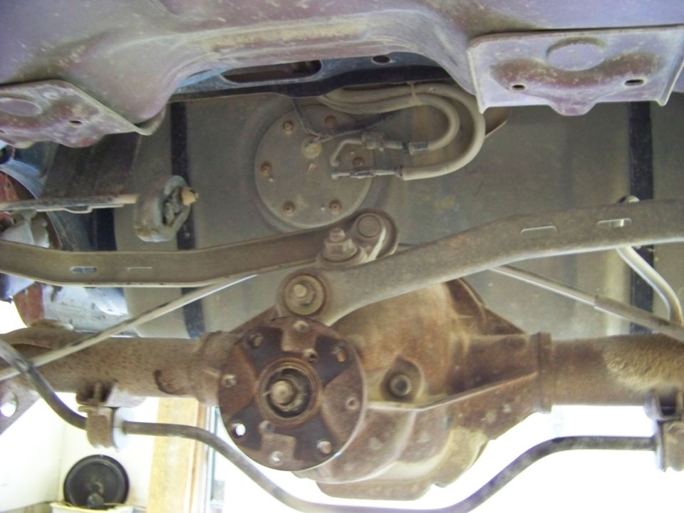 Underside view of a car's rear axle and fuel pump assembly