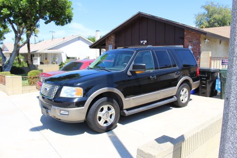 2003 Ford Expedition - A black 2003 Ford Expedition is parked in a driveway next to a red vehicle.