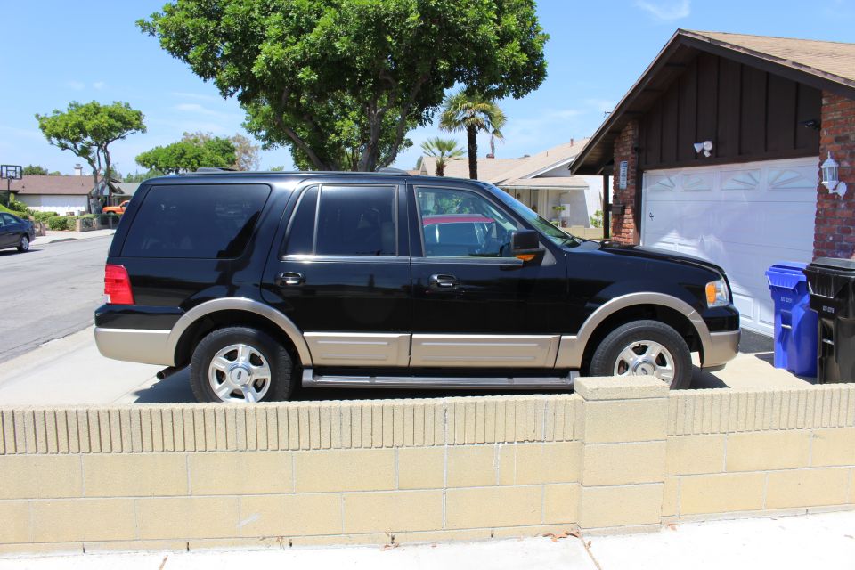 Black 2003 Ford Expedition SUV with tan lower trim parked in a driveway