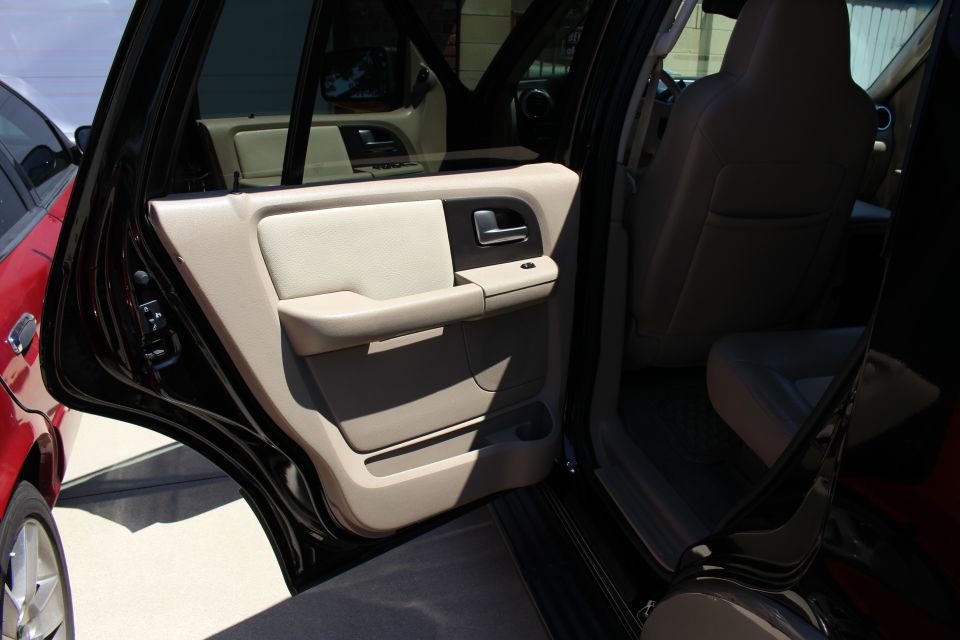 Black 2003 Ford Expedition interior with tan door panel and seats, viewed from the side