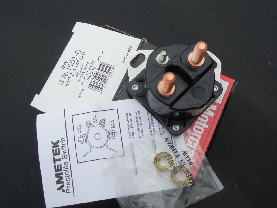 Black solenoid relay switch with copper studs, box labeled SW-1951-C, and hardware bag