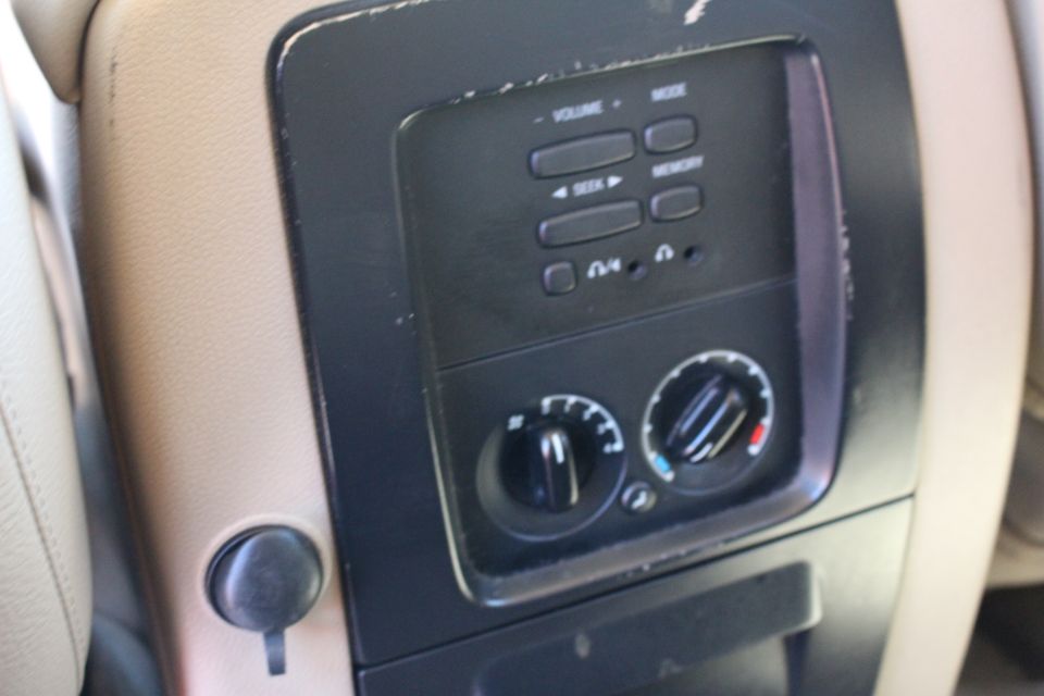 Close-up of climate controls and power outlet in a vehicle's center console