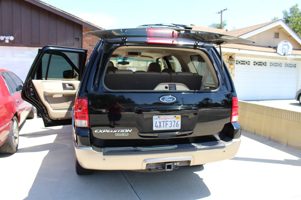 Black Ford Expedition with rear hatch and driver's side door open. California license plate 4XTF376