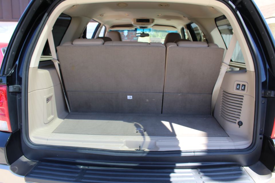 Back cargo area of an SUV with seats folded down. Shows the trunk floor and side panels
