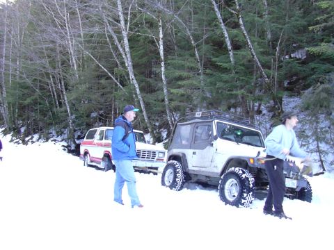 1991 Ford Bronco - A red and white Ford Bronco is parked in the snow, with a Jeep nearby.